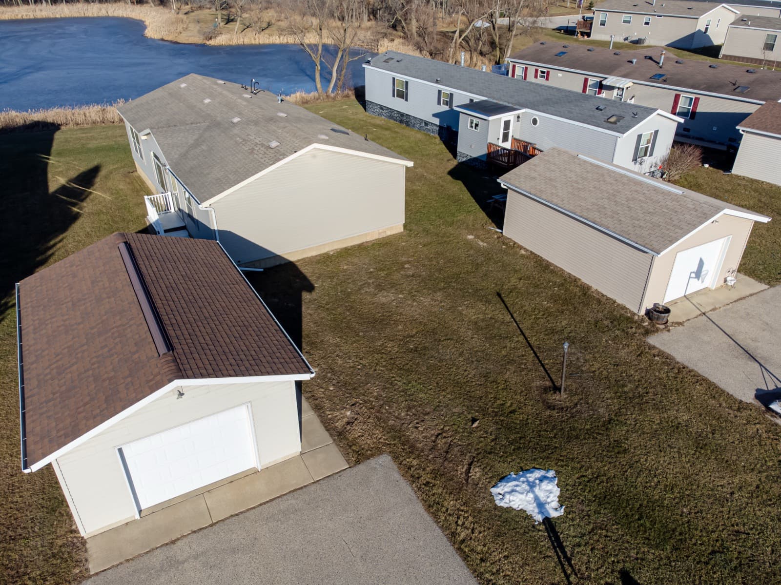 Aerial view of a manufactured home set on a lot with an attached garage