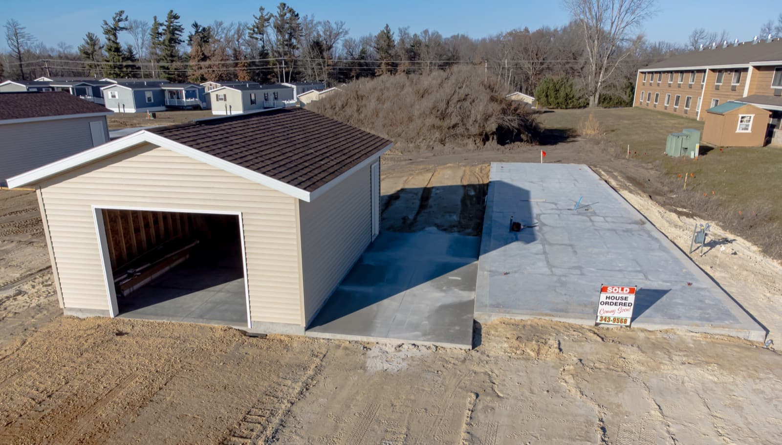 A prepared concrete pad and garage foundation waiting for a home to be set
